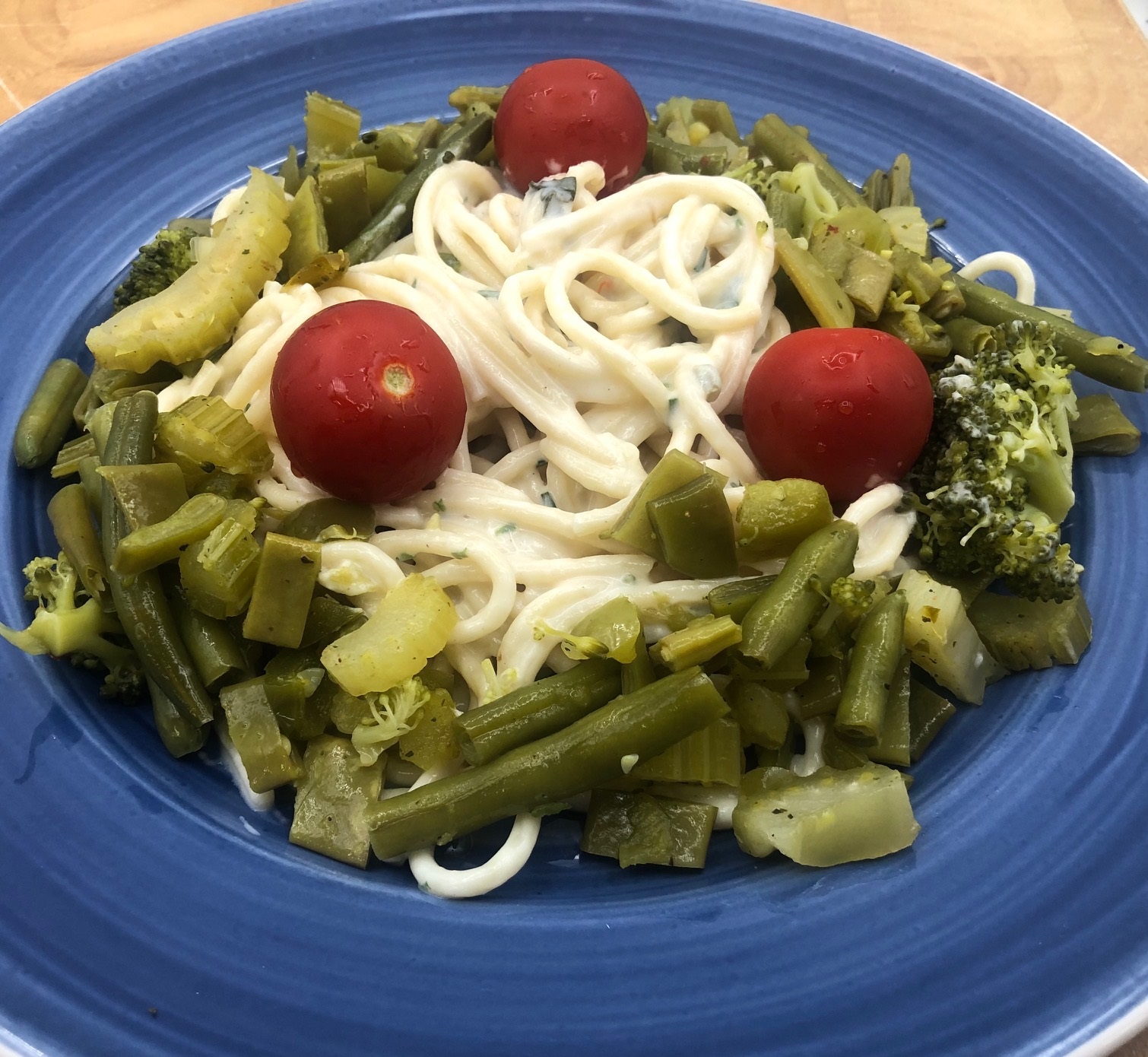 Pasta met kruiden roomsaus en groene groenten.